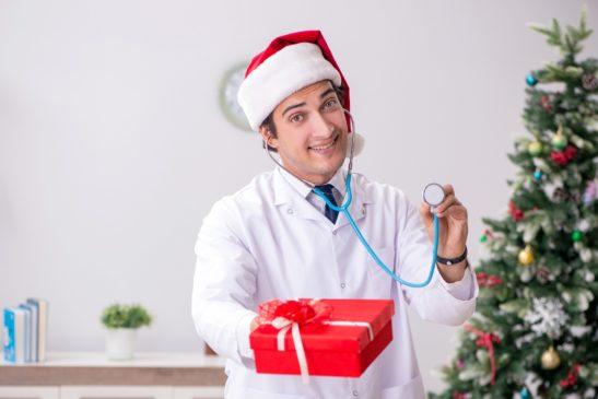 Médico con caja de regalo en el hospital 