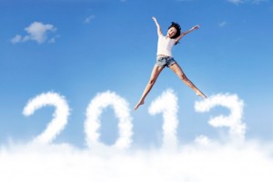 Mujer saltando con fondo de nubes que dicen 2013