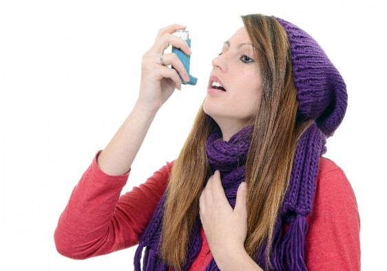 Mujer con bufanda usando difusor en la boca