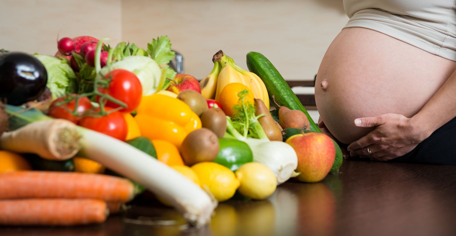 mujer embarazada con vegetales y frutas