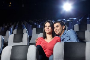 Pareja abrazandose sentados en asientos de cine