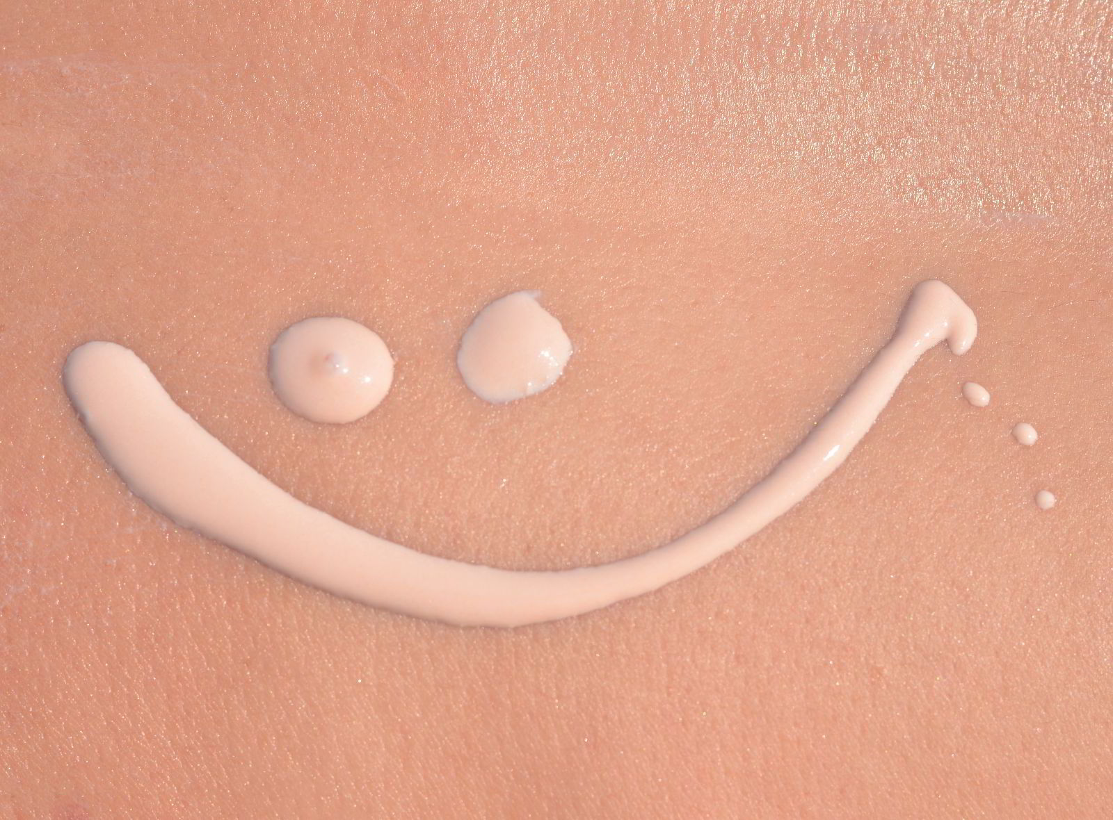 Imagen de piel con crema solar dibujando una sonrisa