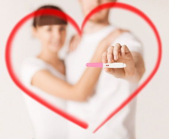 Un dibujo de corazon con una fotografía de un hombre y mujer con una prueba de embarazo en la mano 