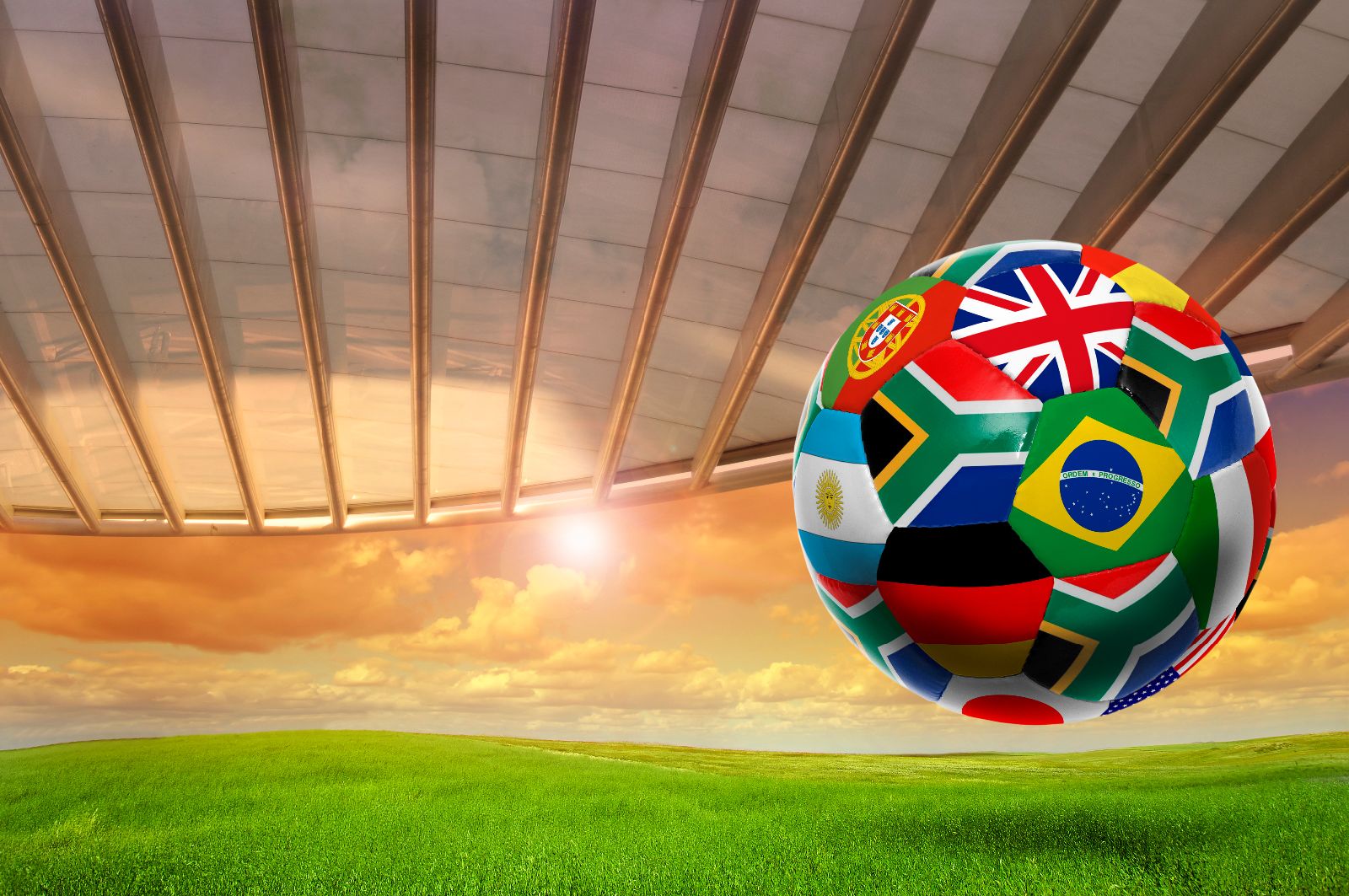 Balón de soccer con banderas del mundo, atardecer de fondo con un techo de cristal en un estadio
