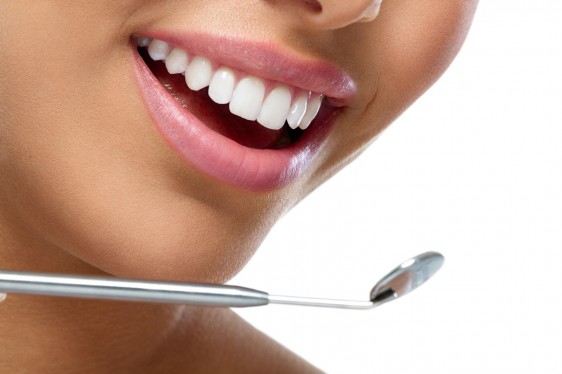 Acercamiento a los dientes de una mujer con un espejo de dentista