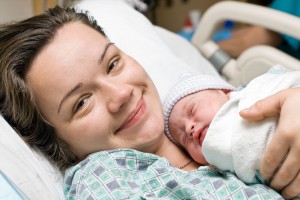 Madre feliz acostada y abrazando a recién nacido