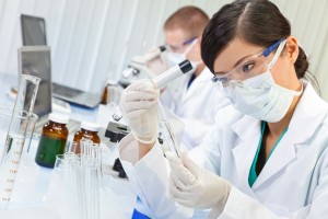 Mujer observando tubo de ensayo en el fondo un laboratorio