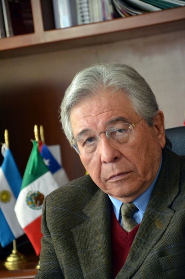 Dr. Fernando Cano Valle, Comisionado Nacional contra las Adicciones, en el fondo un librero con una bandera de méxico