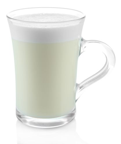 Tazza de cristal con atole de chai en fondo blanco
