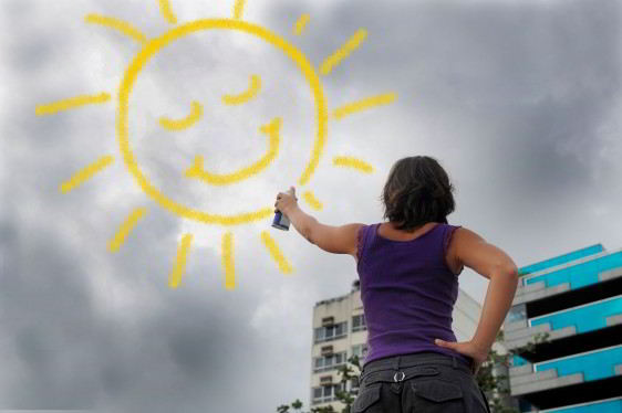 Concepto de optimismo mujer pintando un sol brillante sobre el cielo un cielo obscuro