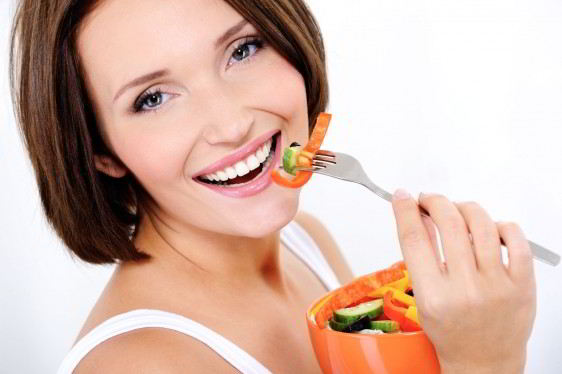 happy attractive woman eats vegetable salad