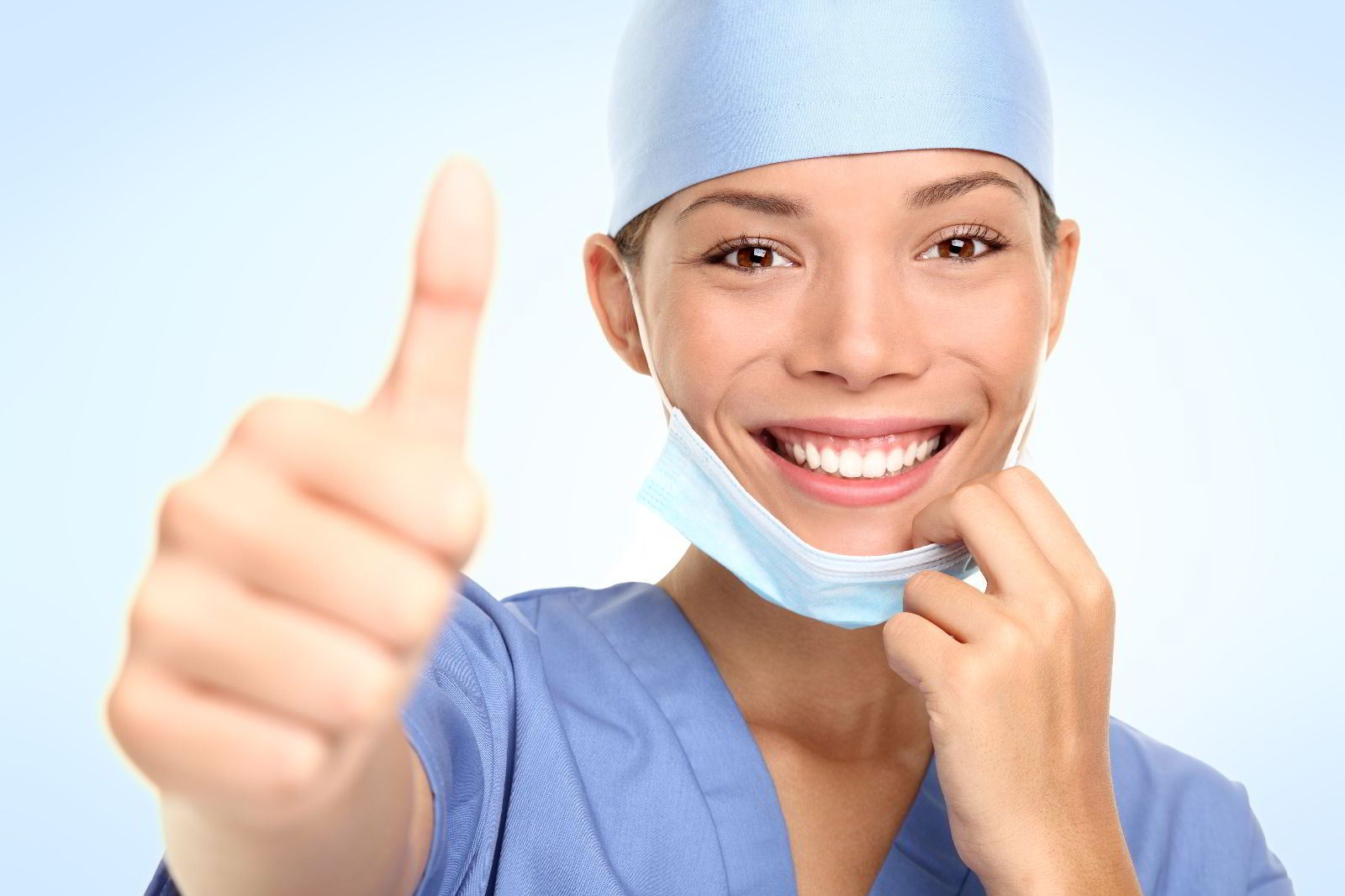 Doctora con traje azul mostrando mano con el dedo pulgar hacia arriba