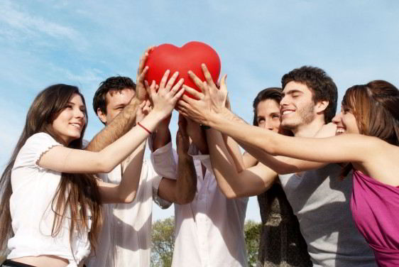Jóvenes reunidos uniendo sus manos en un corazón