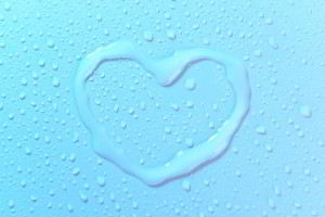 Un corazón dibujado con agua sobre una superficie azul