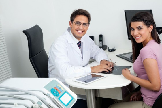 Dentista y paciente sonriendo en consultorio