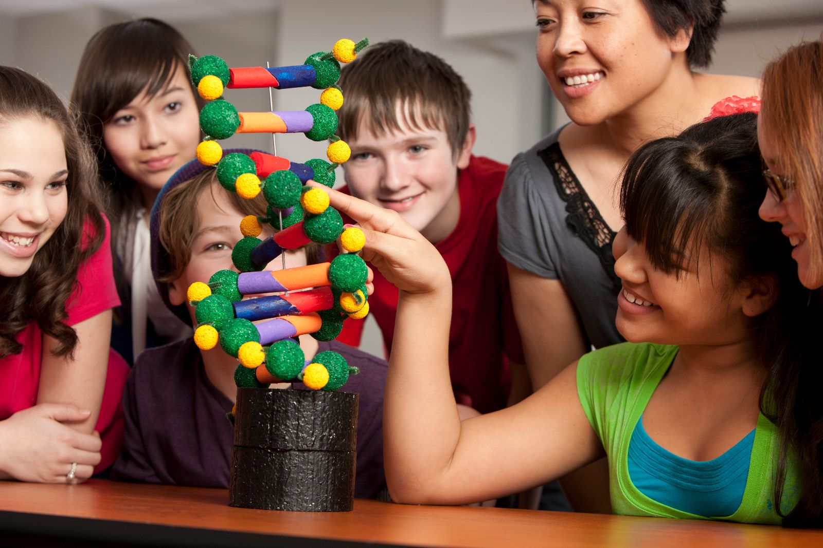 niñas y niños jugando con un modelo a escala de ADN