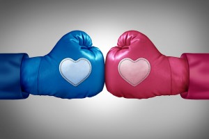 Guante de box azul con un corazón enfrentado a otro guante de ox rosa con un corazón