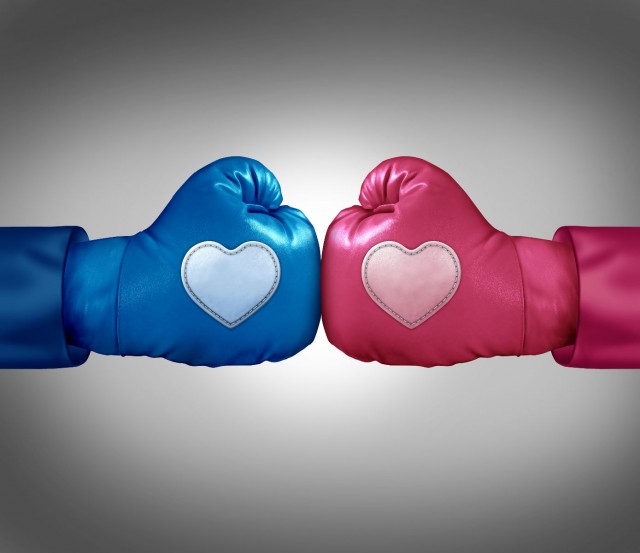 Guante de box azul con un corazón enfrentado a otro guante de ox rosa con un corazón