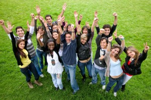 Grupo de jovenes con los brazos arriba en señal de animo