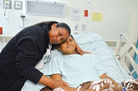 La madre María Jesús Hernández Hernández abrazando a José Trinidad Hernández Hernández que se encuentra acostado en cama