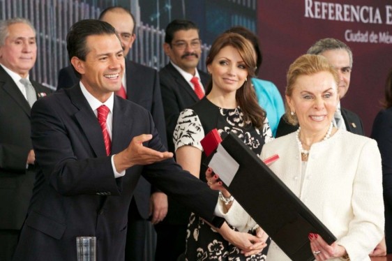 Presidente entrega carpeta negra a doctora Raquel Gerson al fondo publico aplaudiendo