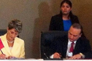 Secretaria de Salud, Mercedes Juan con banderin de Panama y Ministro de Salud de Panamá, Javier Antonio Díaz González de Mendoza con banderin de México firmando documento