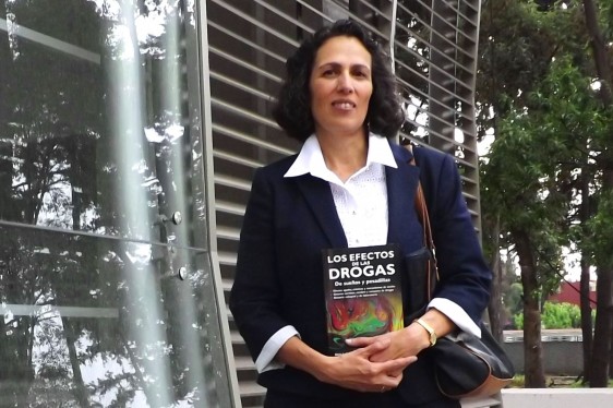 Silvia L. Cruz de pie sosteniendo su libro en las manos