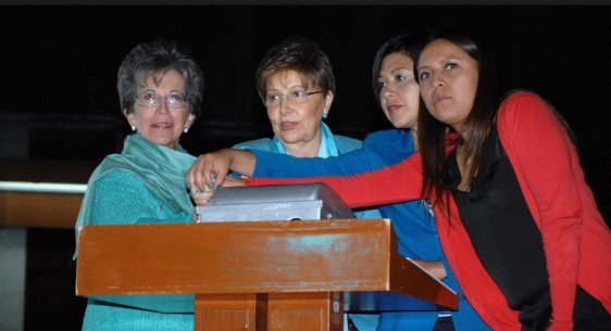 Mujeres en un podium apretando simultáneamente un botón