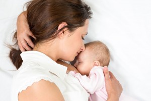 Mujer recostada abrazando a bebe