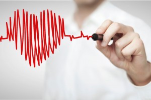 Una persona pinta en un vidrio con plumin rojo un corazón con rayas horizontales que simulan es electrocardigrama