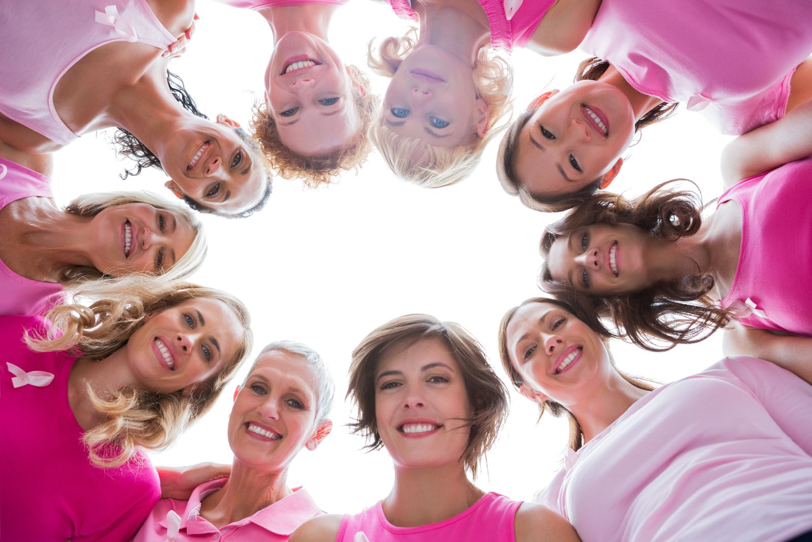 Mujeres con camiseta rosa sonriendo