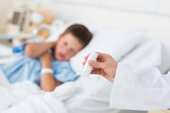 Mpedico sostiene dosificador en la mano al fondo un niño en cama