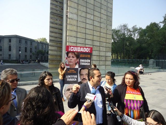Manifestantes con carteles enfrente de la Secretaría de Salud en Paseo de la Reforma