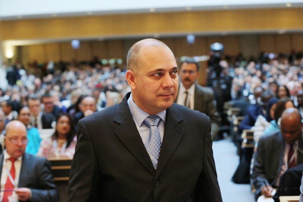 Roberto Morales Ojeda al fondo personas en un auditorio