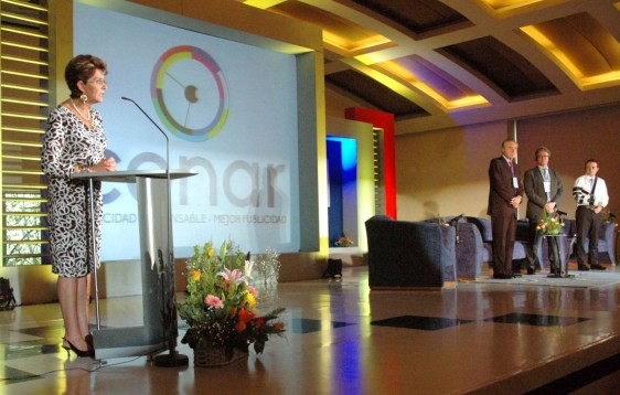 Secretaria de Salud en un podium al fondo el logotipo de CANAR