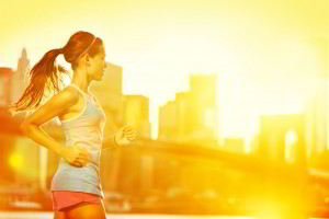 Mujer corriendo con una puesta de sol naranja