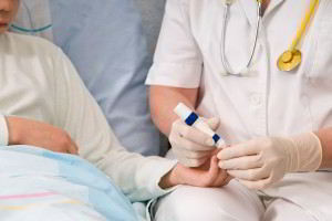 Médico sentado tomando la mano de paciente en cama con aparato en la mano