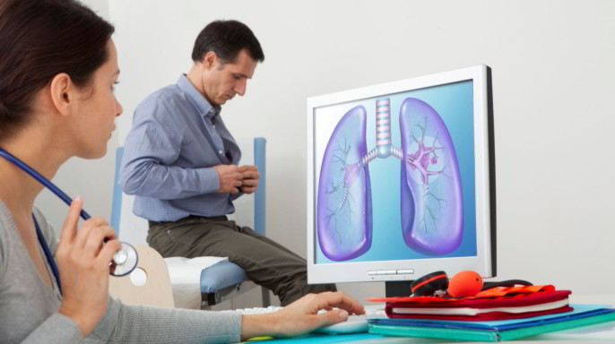 Doctora revisando imagen de pulmón atrás un paciente