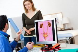 Mujer en consulta con un urologo, el urologo observa una pantalla de computadora