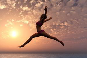 Mujer saltando al fondo una puesta del sol en el oceano