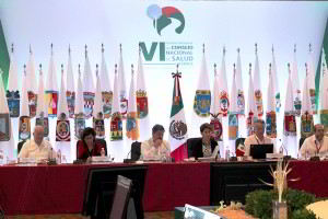 Personas sentadas en una mesa atrás las banderas de los estados de méxico