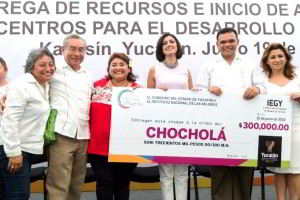 Grupo de funcionarios sosteniendo cartel que simula ser un cheque