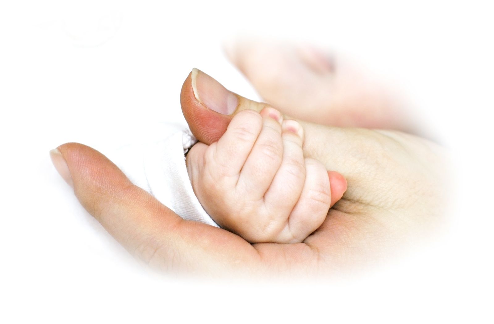 Acercamiento a la mano de una mujer con un bebe agarrando su dedo pulgar