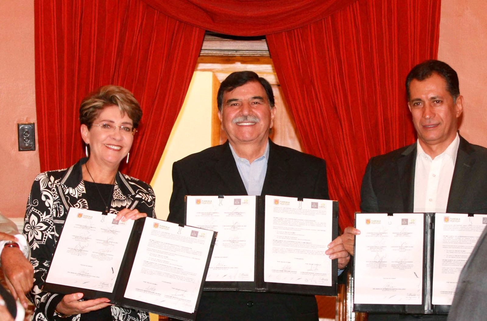 De izquierda a derecha Mercedes Juan, Mario Anguiano Moreno y Mariano González Zarur sosteniendo un documento