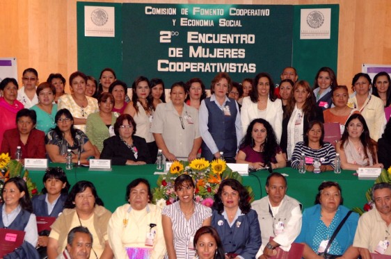 Grupo de mujeres atrás anuncio con el texto "2º Encuentro de Mujeres Cooperativistas"