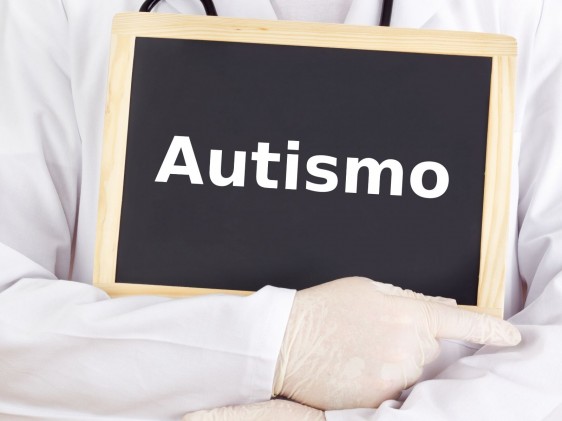 Médico sosteniendo pizarron con la palabra autismo
