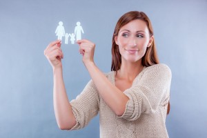Mujer sosteniendo recorte de papel de familia en sus manos