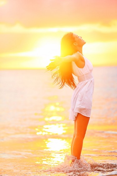 Mujer abriendo los brazos en un amanecer