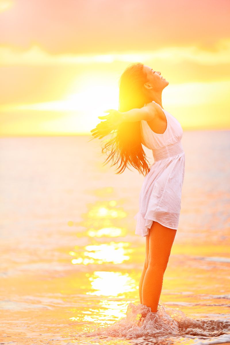 Mujer abriendo los brazos en un amanecer