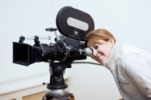 Mujer observando en una cámara de ciine una escena